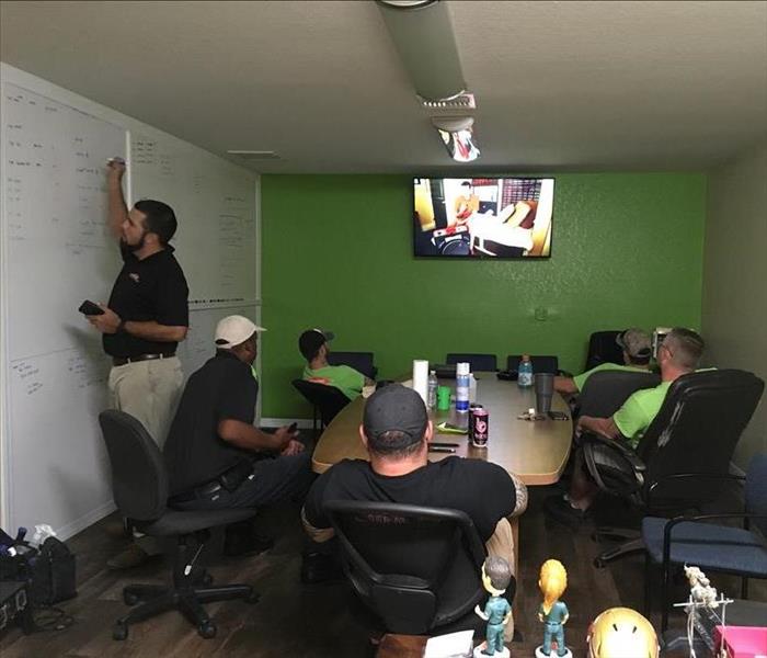 SERVPRO of Ocala employees in conference room watching a training video on mold remediation