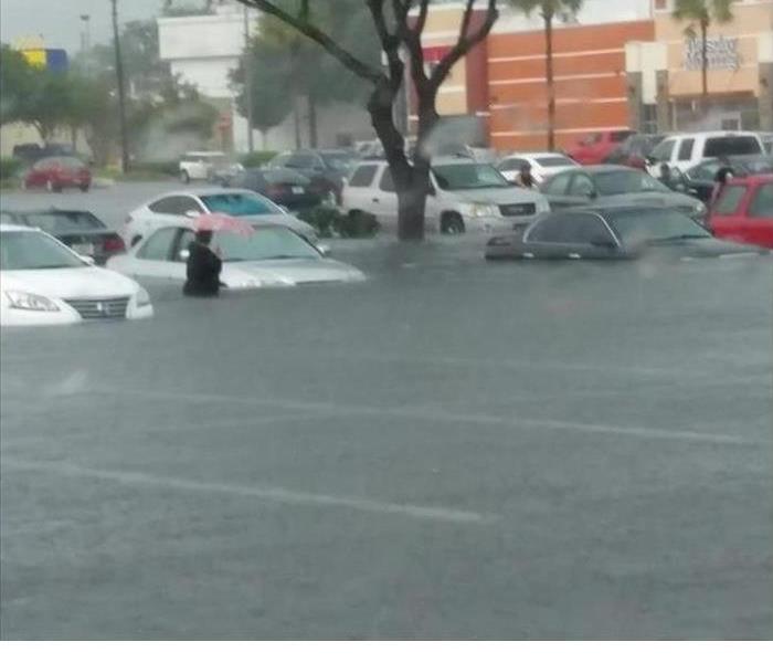 Picture of a parking lot with person walking through waist deep water